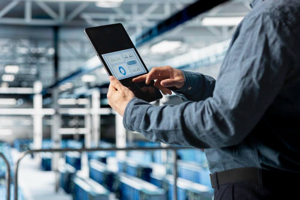 Homem mexendo no tablet com informações da empresa